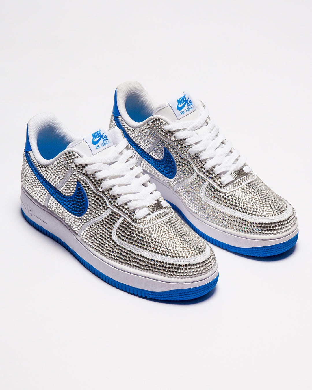 Silver and blue sneakers with a prominent Nike logo on a white background