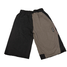 Back flat lay view of the Bottega Desires three-quarter sweat shorts, highlighting the multi-paneled cut-and-sew design with solid charcoal and black fleece segments divided down the center seat and legs.