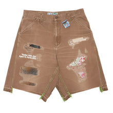 Front flat lay view of the Better With Age 'Double Wide' carpenter shorts in a heavily sun-faded chocolate brown duck canvas, showcasing a relaxed wide-leg workwear silhouette, classic utility pocket styling, multiple intentional raw-edge distressed holes on the thighs, hand-sewn patchwork repairs, and unique multi-colored contrast graphic transfers scattered across the front legs.
