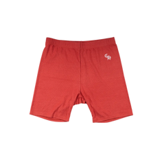 Front flat lay view of the Chrome Hearts 'Bad Seed' women's biker shorts in a vibrant athletic red performance stretch blend, showcasing a form-fitting mid-length athletic silhouette, a thick supportive flat-knit comfort waistband, clean tonal compression stitching along the inseams, and a small white signature Chrome Hearts gothic font monogram printed cleanly on the upper left hip panel.