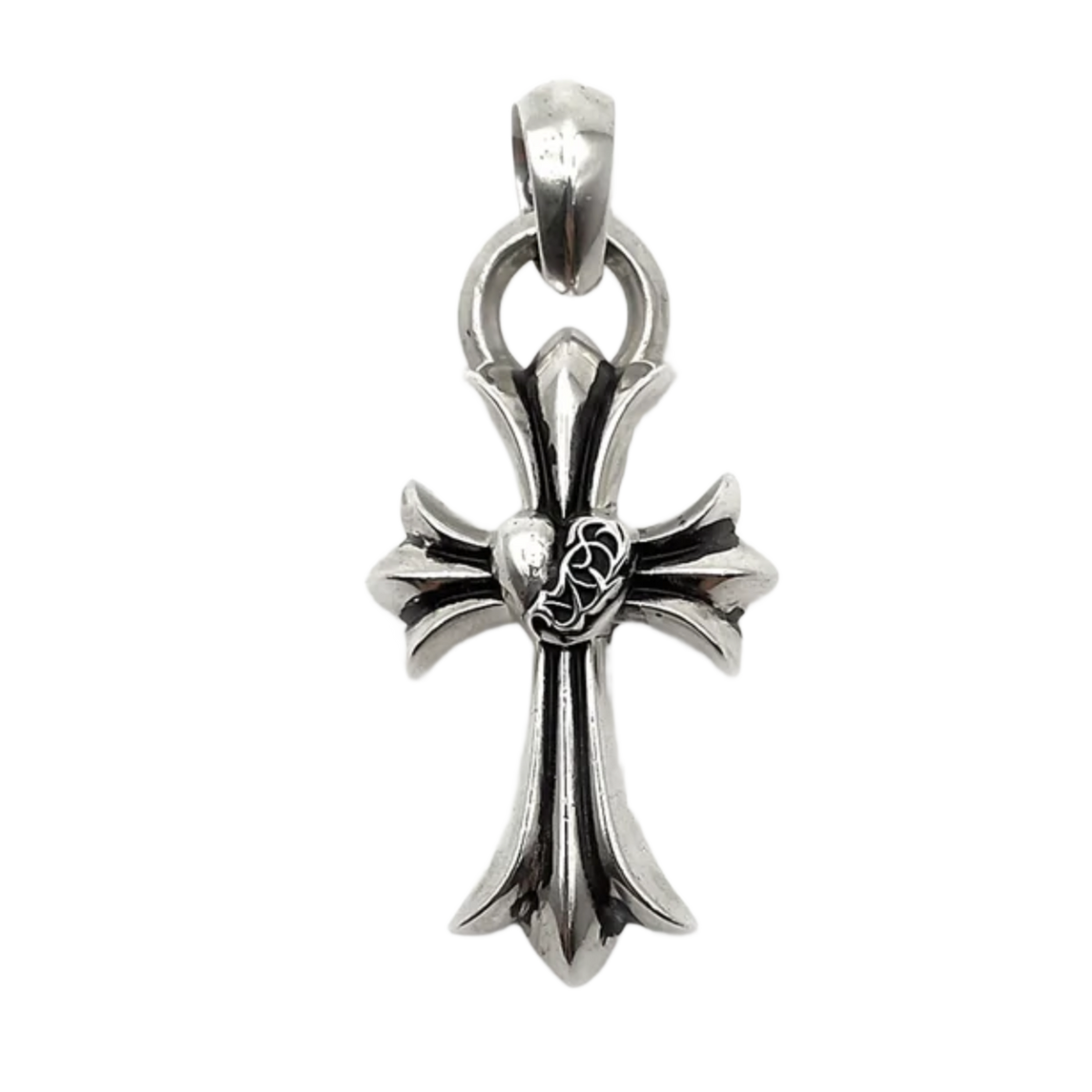 A detailed close-up studio layout view of the Chrome Hearts cross pendant, showcasing a solid sterling silver sculpted cross body with a striking oxidized antique finish, featuring a dimensional raised heart wrapped in intricate vine scrollwork at the central intersection, completed by a heavy integrated circular ring and polished top bale loop.