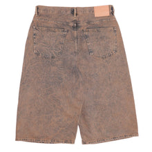 Back flat lay view of the brown oil-wash Acne Studios denim shorts, showcasing the loose skater-style profile, classic rear patch pockets, and the iconic pink brand leather patch on the right waistband.