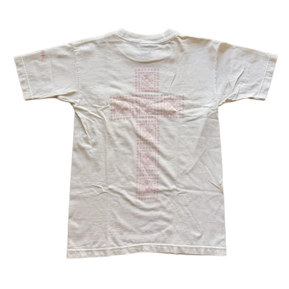 Back flat lay view of the cream vintage Chrome Hearts graphic t-shirt, highlighting the classic relaxed drape across the shoulders and a straight-cut lower hemline, dominated by a large, central pastel pink signature cemetery cross design motif screen-printed vertically down the center spine panel.