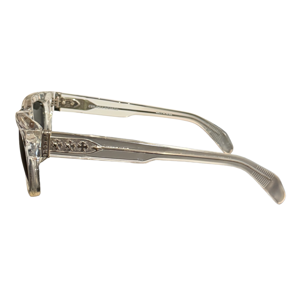 A side profile view of the Chrome Hearts 'Dick Fitzener' sunglasses, emphasizing the translucent clear acetate arm construction, the structural wire core visible inside, and the intricate sterling silver hardware embellishments decorating the hinge area.