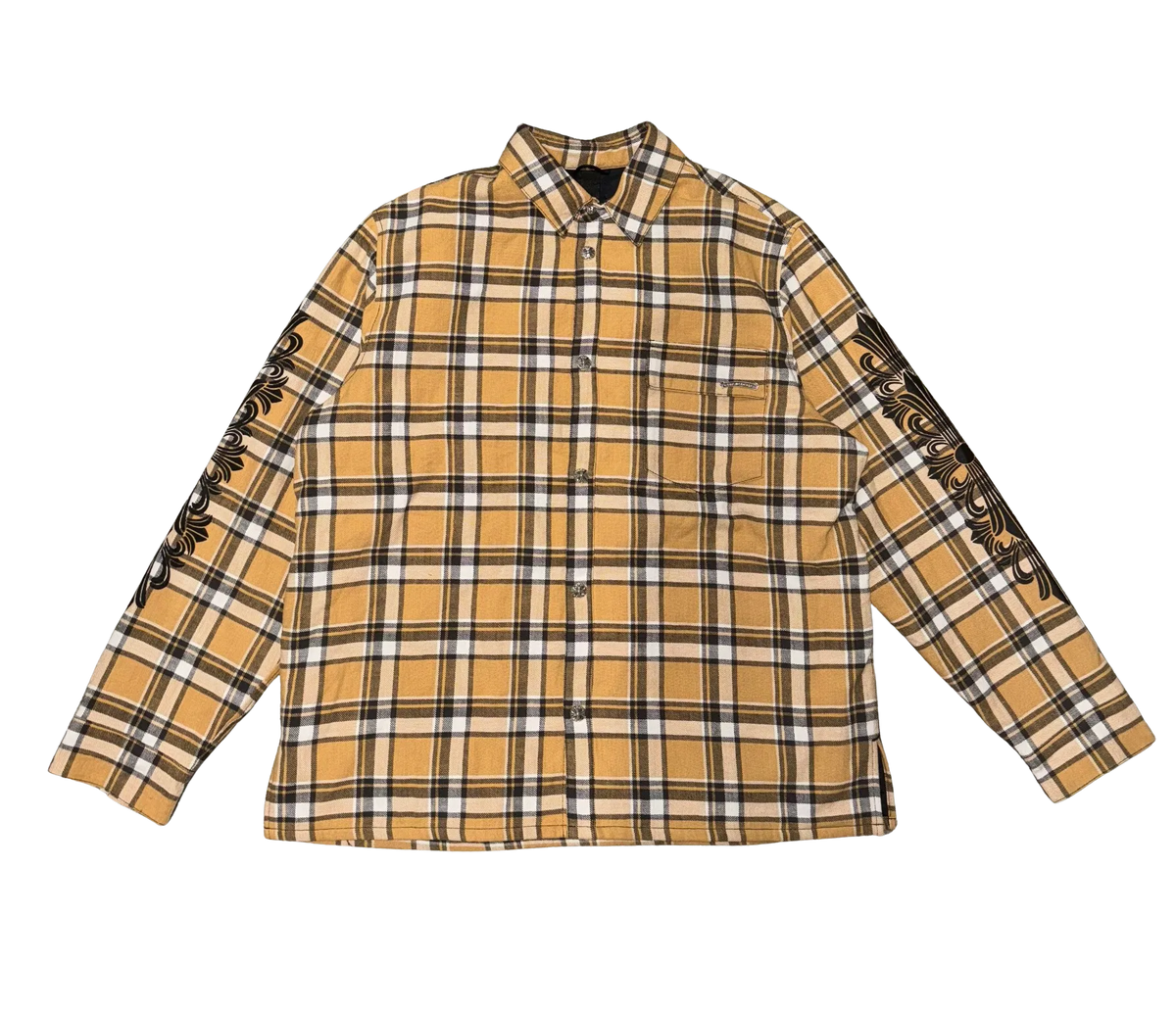 Front flat lay view of the Chrome Hearts shirt jacket in a heavyweight brushed cotton flannel, showcasing a traditional tan, black, and white plaid check pattern, a structured fold-over pointed collar, a full-length hidden center button placket, long relaxed sleeves with buttoned cuffs, a straight lower hemline, and a relaxed boxy tailoring layout.