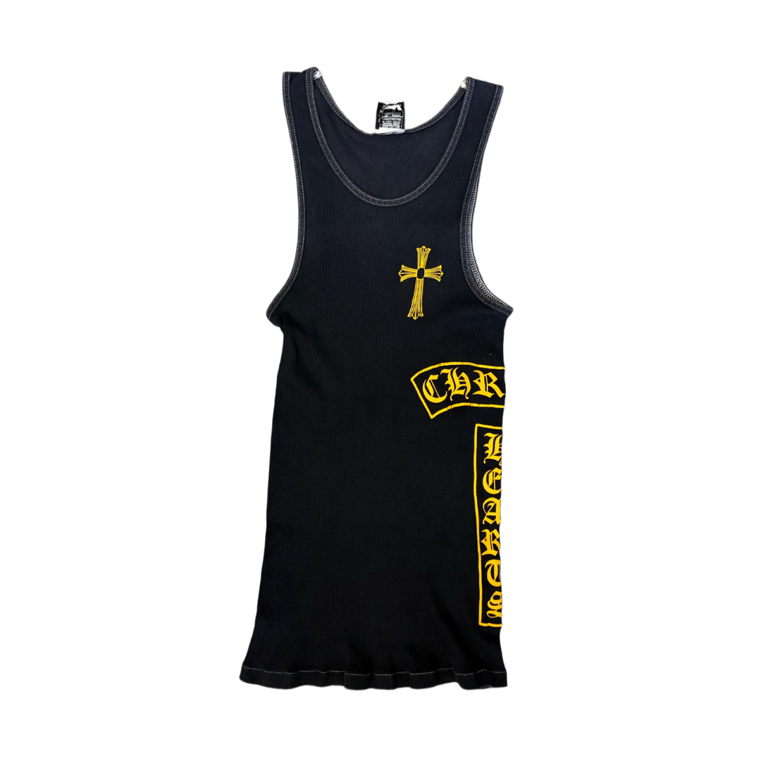 Front flat lay view of the vintage Chrome Hearts sleeveless tank top in a premium fine-ribbed navy blue cotton knit, showcasing a form-fitting athletic silhouette, a deep scoop neckline, a small white graphic printed under the inner back neck, a large bright yellow gothic cross emblem centered on the chest, a curved yellow 'CH' script monogram over the left ribcage, and a bold yellow vertical column of repeating gothic cross graphics cascading down the lower left side torso.
