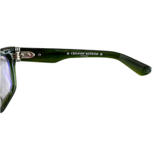A close-up view of the interior left temple arm of the Chrome Hearts glasses, displaying the metallic hinge mechanism alongside the ornate white printed 'CHROME HEARTS' gothic branding and signature crosses.