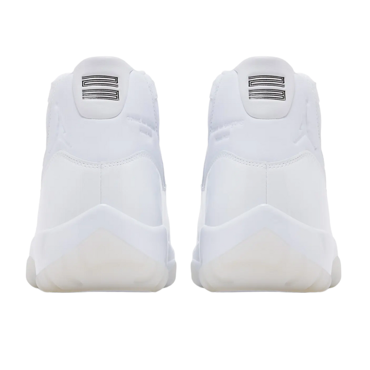A back-facing view of both white Jordan 11 x Comme des Garçons sneakers, featuring the smooth white leather heels with debossed tonal Jumpman logos, white leather pull tabs, and white rubber outsole pods.