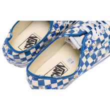 A close-up view looking down into the open heel collar cavity of both shoes, highlighting the cream fabric padded interior lining and the clean, bold black co-branded 'Vans x Mattias Gollin' logo print stamped squarely onto the tan padded heel insoles.