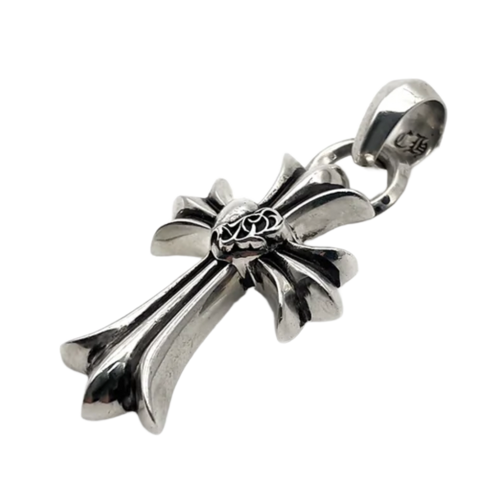 A three-quarter angled profile view of the sterling silver heart cross pendant resting flat, emphasizing the heavy architectural thickness and sculptural depth of the flared cross arms, the deep black oxidized recesses of the central heart design, and the high-polish sheen of the metal facets.