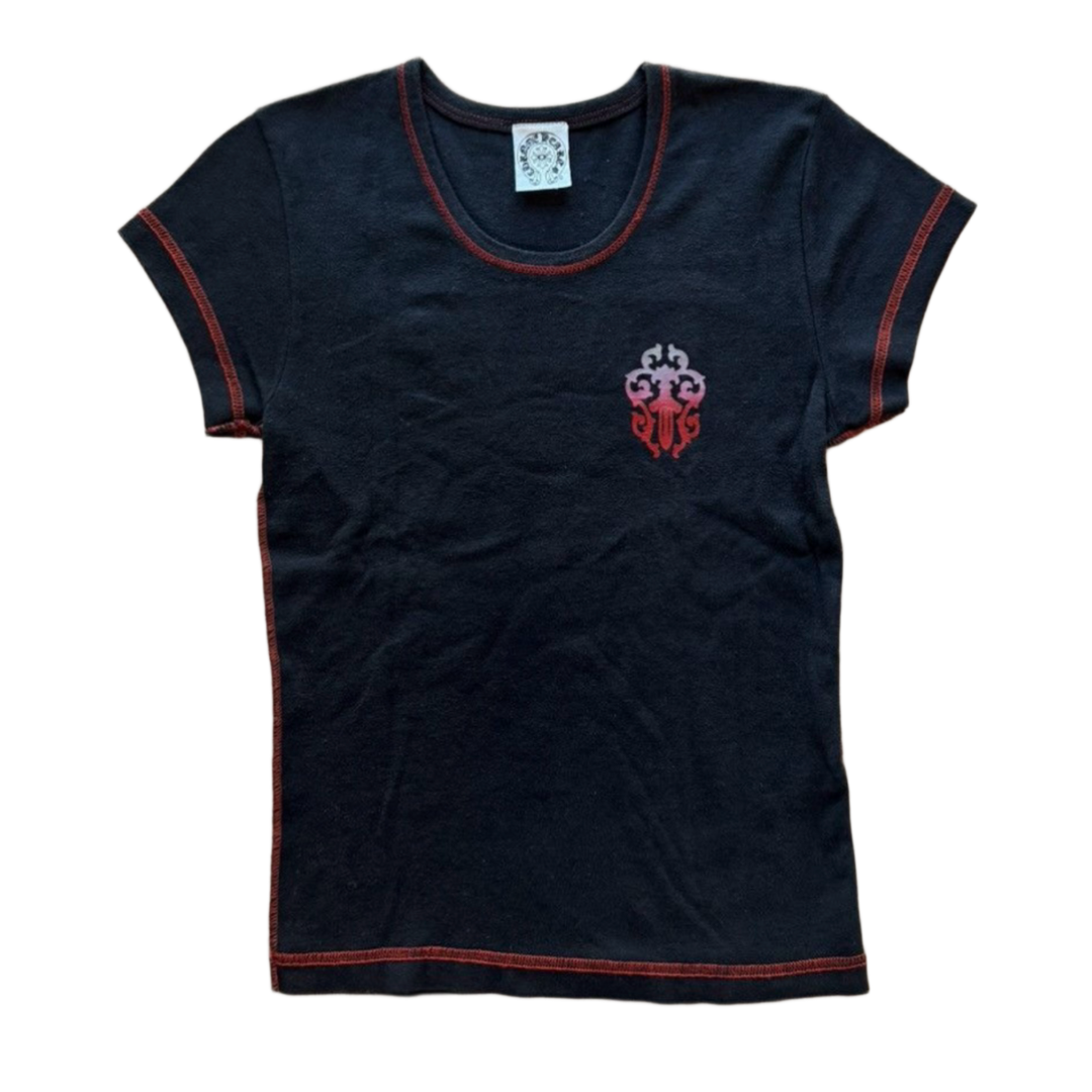 Front flat lay view of the vintage Chrome Hearts women's baby tee in a soft, premium washed black cotton knit, showcasing a form-fitting cropped y2k silhouette, a wide scooped neck collar with a white internal brand label, short sleeves highlighted by vibrant contrast red flatlock coverstitching along the hems, and a small red and white graphic emblem screen-printed over the left ribcage.