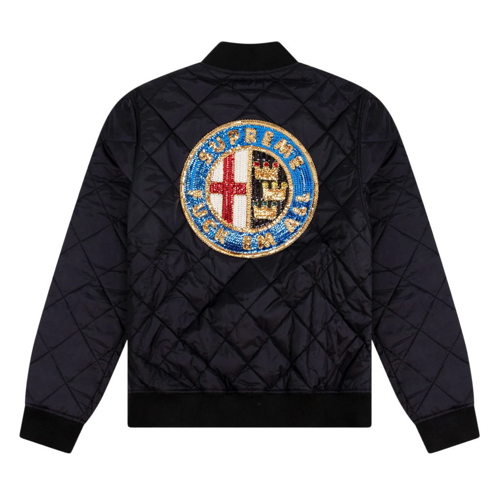 Back flat lay view of the black diamond-quilted Supreme bomber jacket, highlighting the structured outerwear volume across the shoulders and back panel, dominated by a large, intricate circular multi-colored sequin patch emblazoned across the upper back torso depicting an ornate crest design with a red cross, blue detailing, and bold typography.