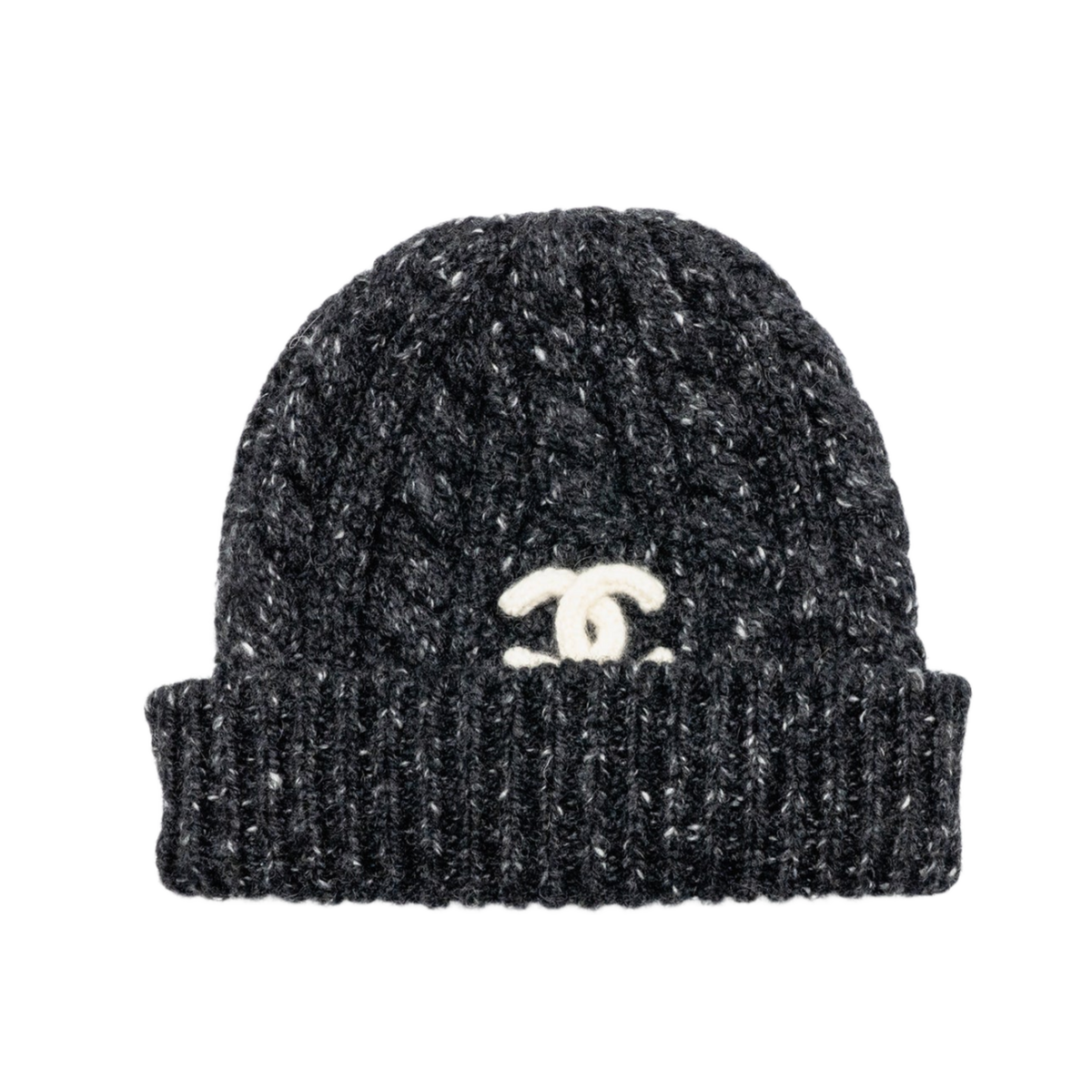 Front studio view of the Chanel beanie, showcasing a premium heavyweight cable-knit cashmere composition executed in a textured black and ecru cream mottled melange yarn pattern, featuring a thick rib-knit fold-over cuff design, a structured watch-cap skull silhouette, and a prominent stark white contrast interlocking 'CC' signature logo patch embroidered centered on the front cuff.
