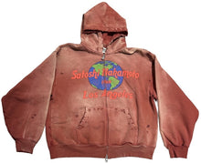 Front flat lay view of the Satoshi Nakamoto '1969 Rock' full-zip hoodie in a sun-faded brick red wash, featuring an oversized boxy silhouette, a prominent raw-edged central seam design, dropped shoulders, split kangaroo pockets, and a colorful circular earth graphic printed across the chest.