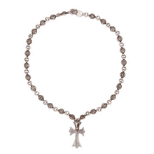 A full-length top-down view of the necklace arranged in an open loop, showcasing the consistent spacing of the textured sphere beads and the vertical alignment of the central cross pendant.