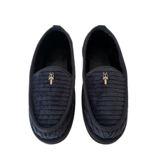 Top-down view of a pair of Chrome Hearts slip-on slippers in navy blue quilted corduroy fabric, featuring a classic rounded toe box silhouette, tonal leather binding trim, and an intricate sterling silver dagger hardware charm centered on each upper tongue panel.