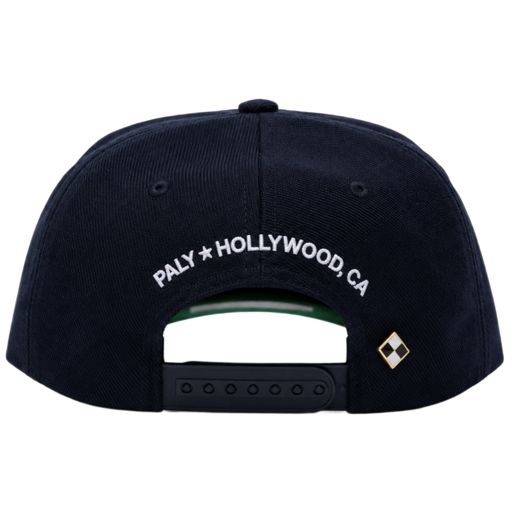 A straight-on rear view of the navy blue Paly canvas cap resting flat, highlighting the low-profile crown posture and uniform panels, featuring an adjustable fabric strap closure with a metallic slider buckle, accented cleanly by white embroidered branding text reading 'PALY HOLLYWOOD CA.' stitched across the rear opening arc.