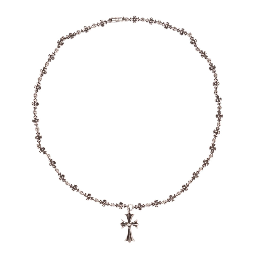 An overview of the Chrome Hearts 'Tiny E' 20-inch necklace arranged in a large circle against a white background, showcasing the repeating chain of miniature cross links leading down to a larger central 'Tiny Cross' pendant.