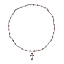 An overview of the Chrome Hearts 'Tiny E' 20-inch necklace arranged in a large circle against a white background, showcasing the repeating chain of miniature cross links leading down to a larger central 'Tiny Cross' pendant.