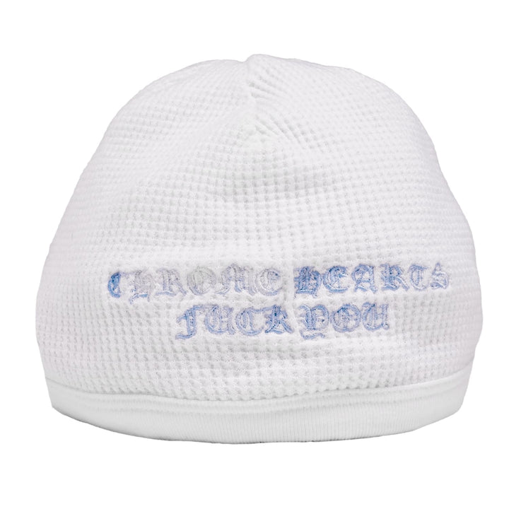Front flat lay view of the Chrome Hearts vintage skull cap beanie in white thermal waffle-knit cotton, featuring bold light blue printed gothic 'CHROME HEARTS' and 'FUCK YOU' script branding wrapped across the front cuff.