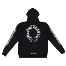 Back flat lay view of the black Chrome Hearts thermal zip-up hoodie, highlighting the relaxed streetwear drape and thick ribbed knit cuffs and hemline, dominated by a large white circular horseshoe brand graphic printed boldly across the upper back torso with its classic signature cross motif at the center.