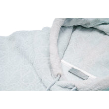 Close-up view of the interior collar neckline, highlighting the plush texture of the light blue towel cotton fabric, a white woven 'DIOR' brand label, and natural sun-faded discoloration around the inner hood seams.