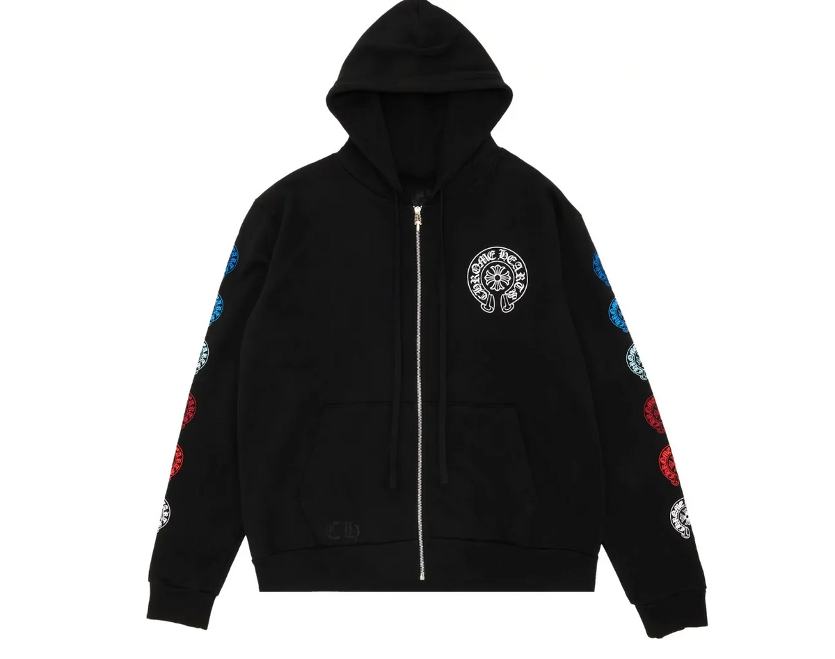 Front flat lay view of the Chrome Hearts zip-up hoodie in heavyweight jet-black cotton fleece, showcasing a relaxed boxy silhouette, a thick structured drawstring hood, a silver metal center zipper track, split kangaroo pouch pockets, a small white signature horseshoe monogram printed on the left chest, and a vibrant multicolor gradient layout of gothic branding graphics running down both sleeves.