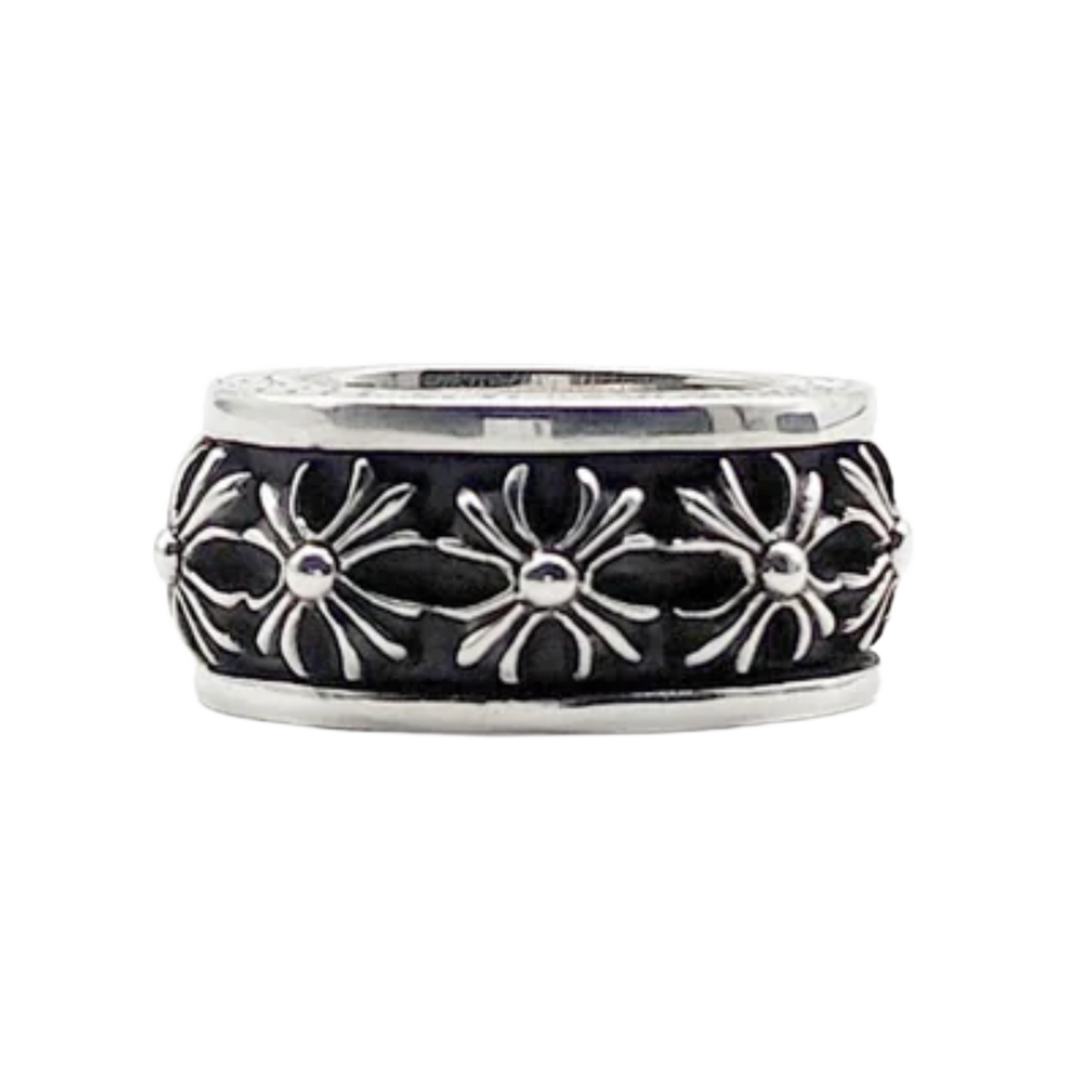 A side view of the wide Chrome Hearts sterling silver spinner ring resting flat, highlighting the central rotating band carved with a repeating pattern of raised, highly detailed gothic plus cross motifs separated by dark oxidization accents.