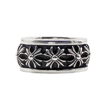 A side view of the wide Chrome Hearts sterling silver spinner ring resting flat, highlighting the central rotating band carved with a repeating pattern of raised, highly detailed gothic plus cross motifs separated by dark oxidization accents.