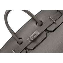 A detailed close-up shot of the open front flap draped backward, highlighting the loose leather sangles, the pristine metallic finish of the open palladium turn-lock spindle, and the fine metallic foiling stamp reading 'HERMÈS PARIS MADE IN FRANCE'.
