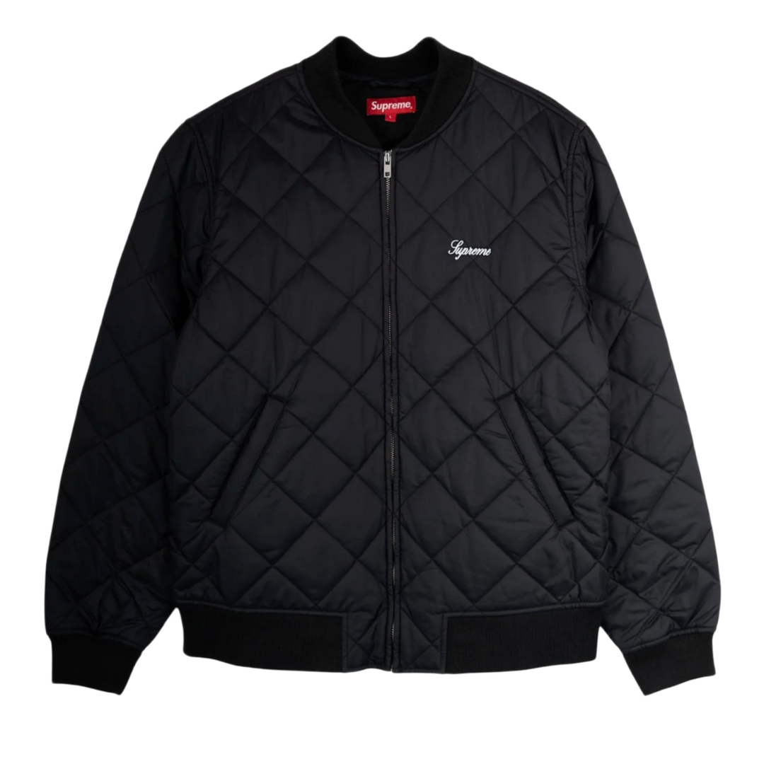 Front flat lay view of the Supreme bomber jacket in a jet-black technical satin shell, showcasing a structured street silhouette defined by a uniform diamond-quilted insulated construction, a ribbed knit baseball-style collar, a silver metal center zipper track, angled lower double-welt hand pockets, matching thick ribbed knit cuffs and hemline, and a small elegant white cursive Supreme script logo embroidered cleanly on the left chest.