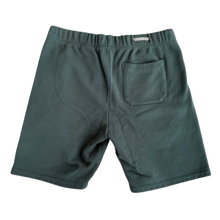 Back flat lay view of the green Chrome Hearts Slo Ride shorts, showcasing a clean, loose athletic profile with solid dark green unadorned fabric panels stretching across the seat and back of the legs.