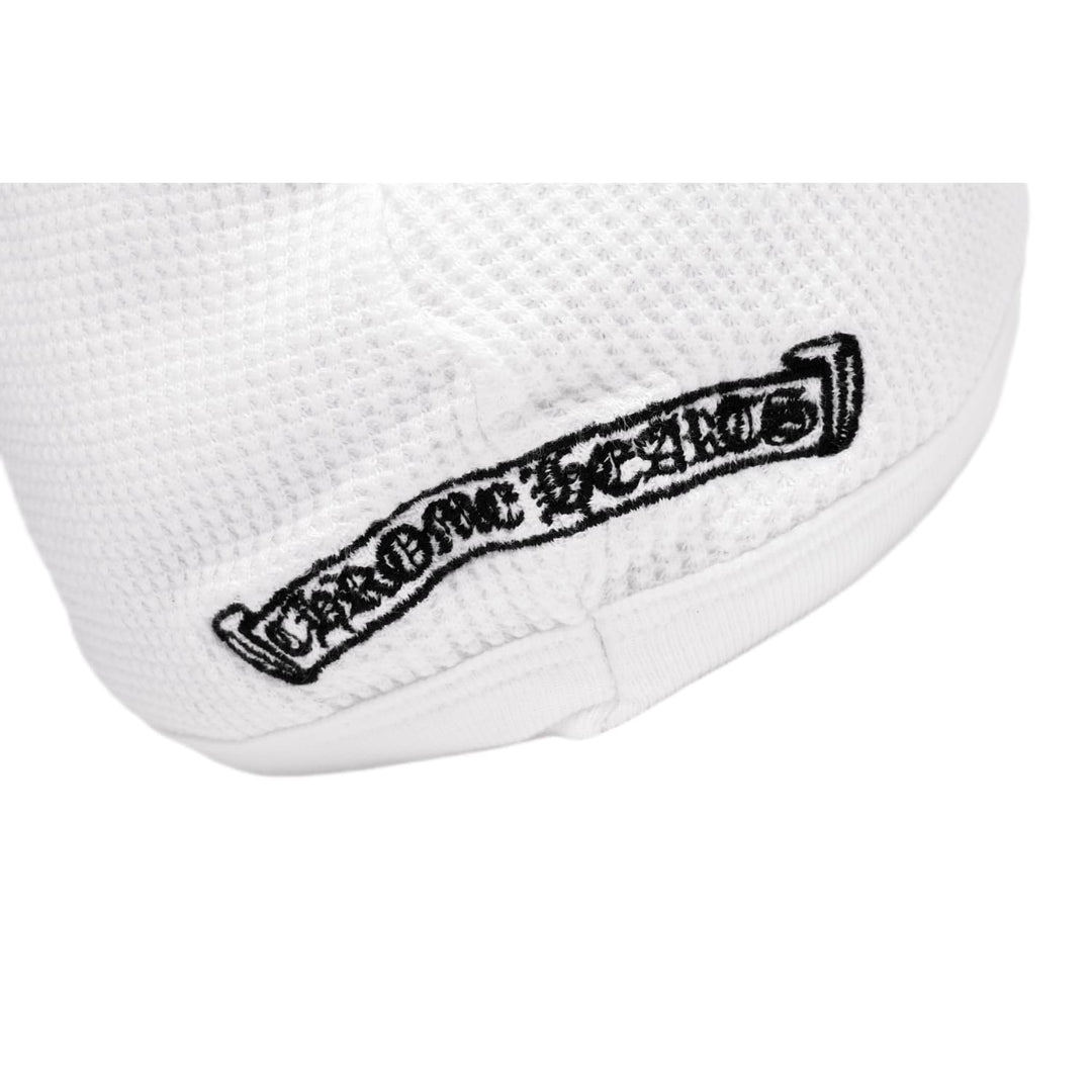 Macro detail of the black Chrome Hearts scroll banner graphic, showcasing the crisp gothic lettering and floral borders contrasting against the white waffle-knit pattern.