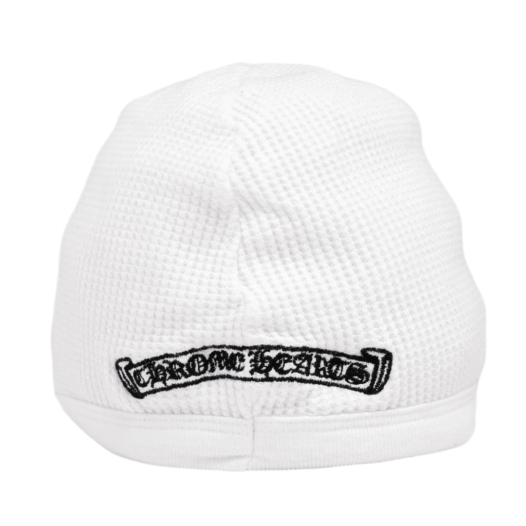 Close-up view of the lower back section of the white skull cap, showcasing a horizontal black Chrome Hearts scroll banner graphic printed cleanly across the thermal knit trim.