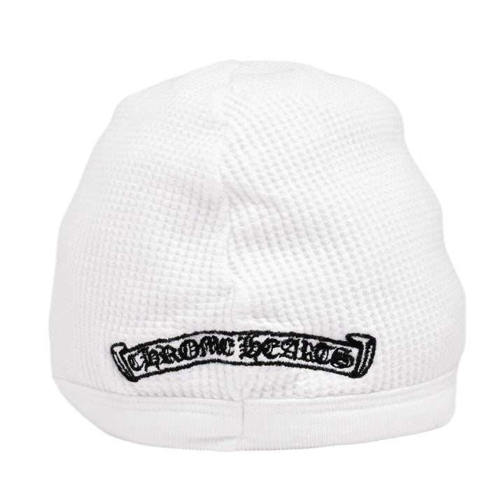 Close-up view of the lower back section of the white skull cap, showcasing a horizontal black Chrome Hearts scroll banner graphic printed cleanly across the thermal knit trim.