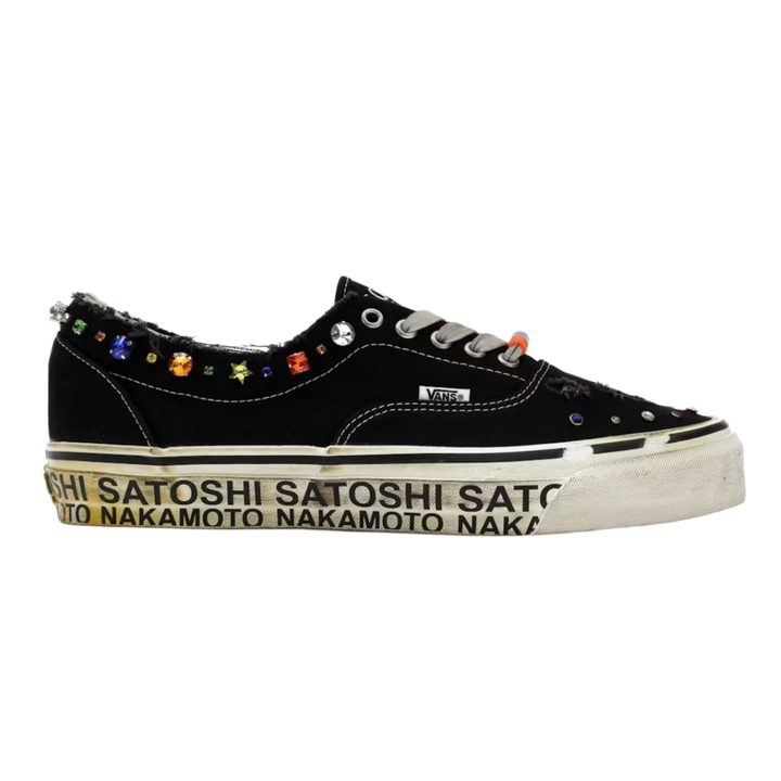 A clean lateral profile view of the Satoshi Nakamoto x Vans 'Lucky Charms' low-top sneaker, featuring a black canvas upper decorated with colorful multi-shaped plastic lucky charm beads along the lace eyelets, a customized cream vulcanized rubber midsole printed with repeating black 'SATOSHI NAKAMOTO' branding, and a classic gum rubber waffle outsole.