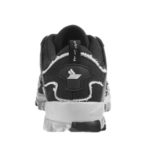 A straight-on rear view of the black and white Sicko Vessel shoe, highlighting the layered technical paneling along the heel counter, sharp contrast white wave patterns wrapping around the lower heel cup, a centered vertical canvas pull loop, and the thick, protective lugged stance of the dual-colored high-traction rubber outsole.