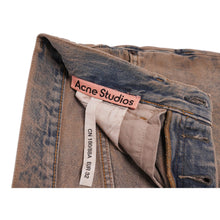 An interior look at the waist opening, showcasing the button fly structure, inner fabric pocket lining, and the classic white woven Acne Studios clothing labels.