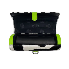 An elevated view looking down at the watch roll unrolled flat, showcasing a rich navy blue soft suede interior lining equipped with a matching plush navy blue suede watch cushion cylinder, framed beautifully by the exposed neon green zebra leather flap and a sterling silver accent brand plaque.