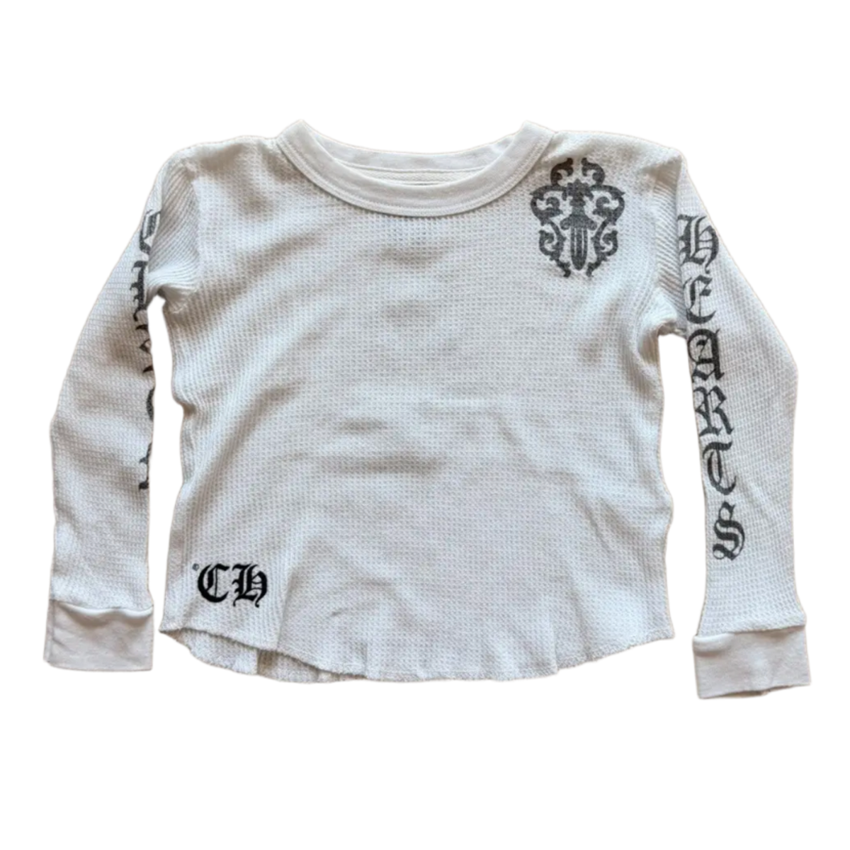 Front flat lay view of the Chrome Hearts vintage kids long-sleeve thermal top in a light baby blue or off-white waffle-knit cotton, showcasing a relaxed crewneck silhouette, tight ribbed cuffs, a black gothic 'CH' monogram printed on the lower right hip, and bold black gothic scroll lettering running down the length of the left sleeve flanked by a stylized cemetery cross motif on the left shoulder.