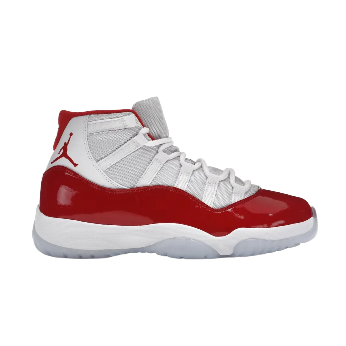 A clean lateral profile view of the Air Jordan 11 Retro 'Cherry' sneaker, featuring a crisp white ballistic mesh upper with matching white leather heel panels, a vibrant cherry red patent leather mudguard wrapping the base, a thick white foam midsole, and an icy translucent rubber outsole.