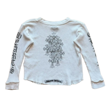 Back flat lay view of the kids Chrome Hearts thermal long-sleeve, highlighting the textured waffle-weave cotton drape across a small youth-sized fit, dominated by a large, central black graphic print screen-printed across the center back torso depicting a detailed gothic cemetery cross arrangement.