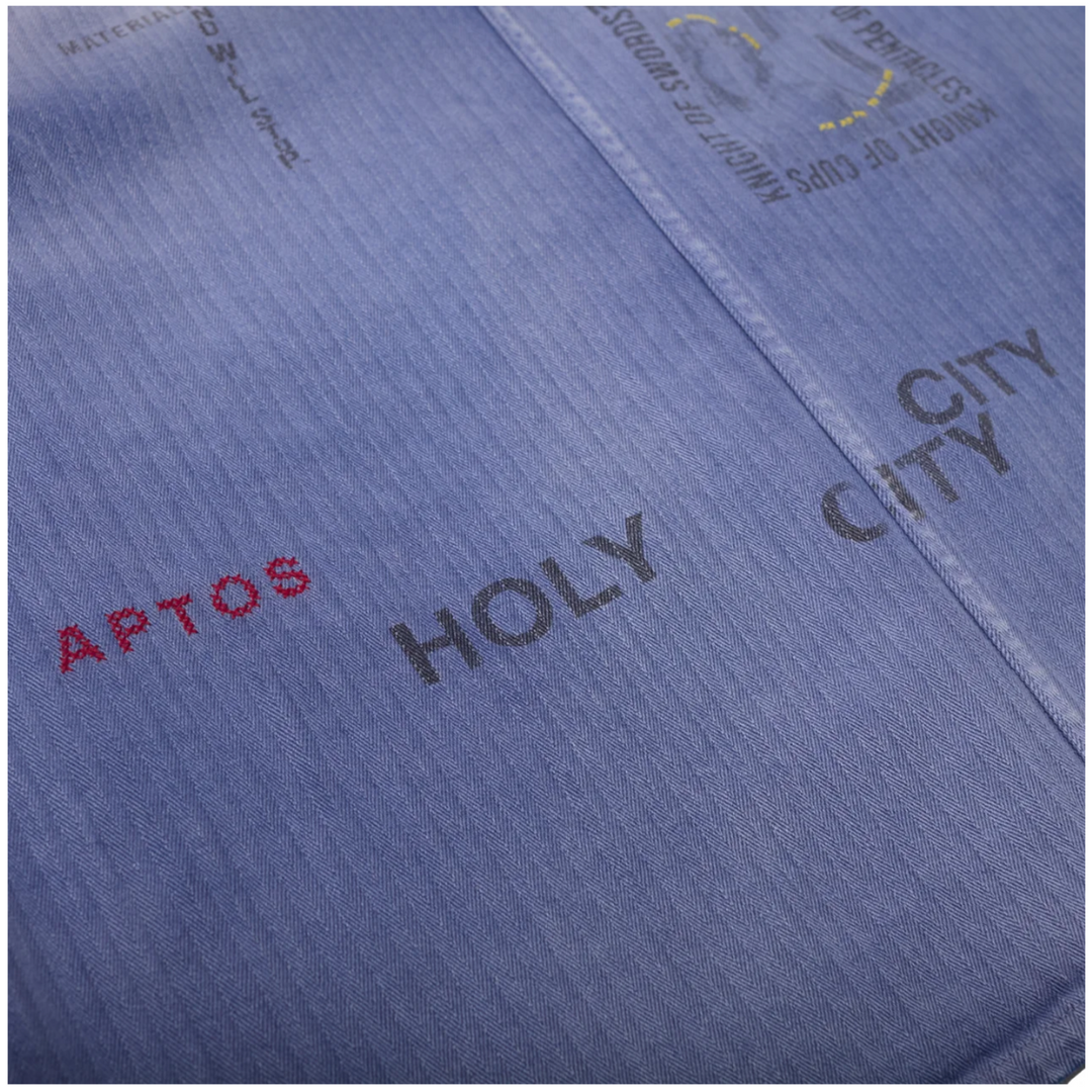 Close-up detail of the lower back on the Paly shirt, showing the vertical herringbone texture, red embroidered 'APTOS' text, and black stenciled 'HOLY CITY CITY' lettering across the central seam.
