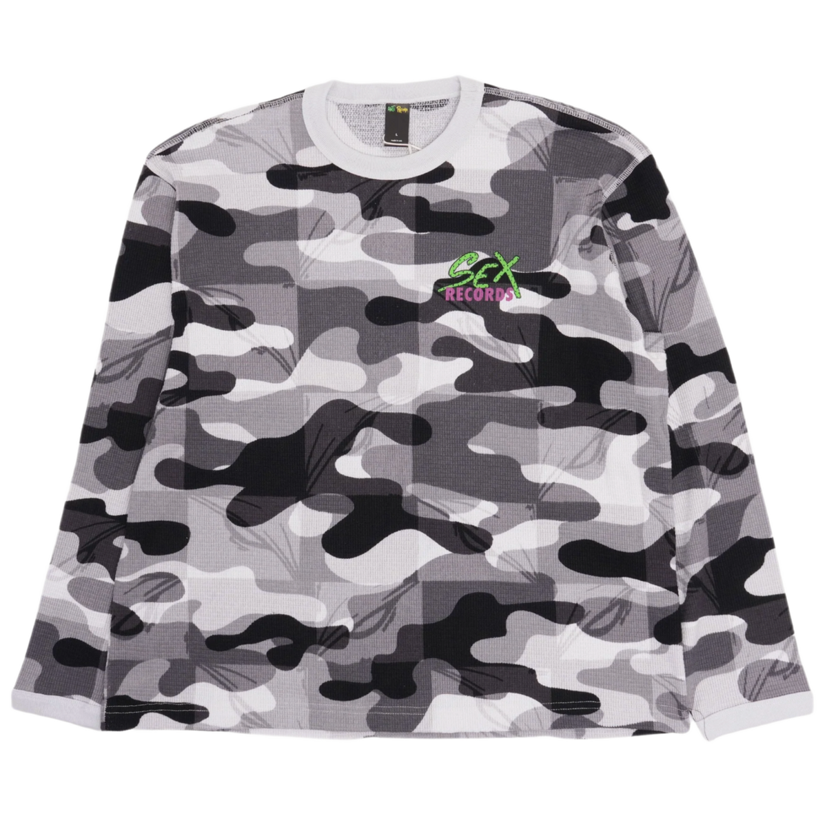 Front flat lay view of the Matty Boy Anti Promo crewneck thermal longsleeve shirt in a grayscale camouflage waffle-knit pattern, featuring a small green and pink cartoon character graphic printed on the left chest below the crew neckline.