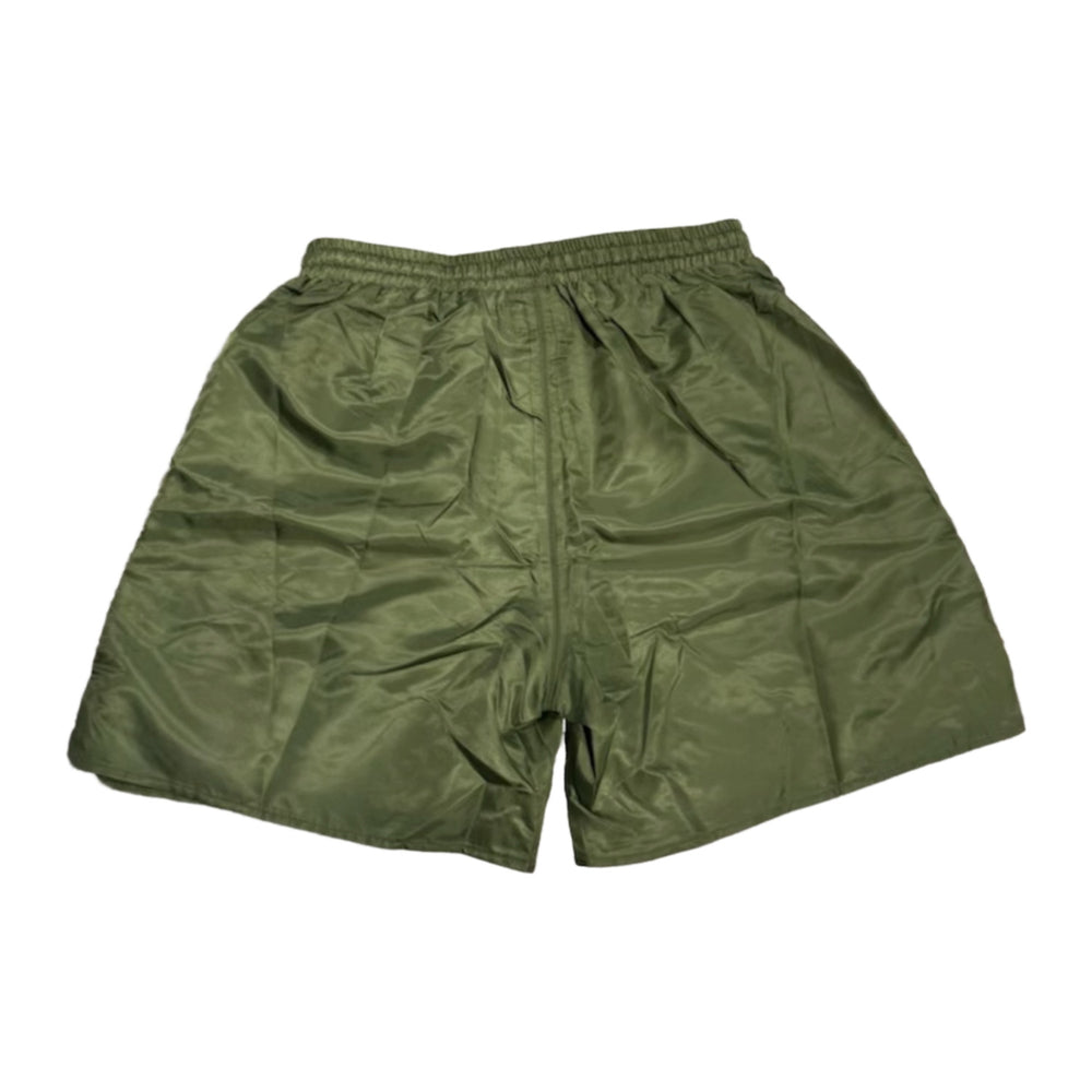 Back flat lay view of the olive green Saint Vanity technical nylon shorts, highlighting the lightweight athletic drape, a structured horizontal back yoke seam panel beneath the elastic waistband, and a clean, unadorned solid green reverse profile with subtle side-snap hardware visible at the margins.