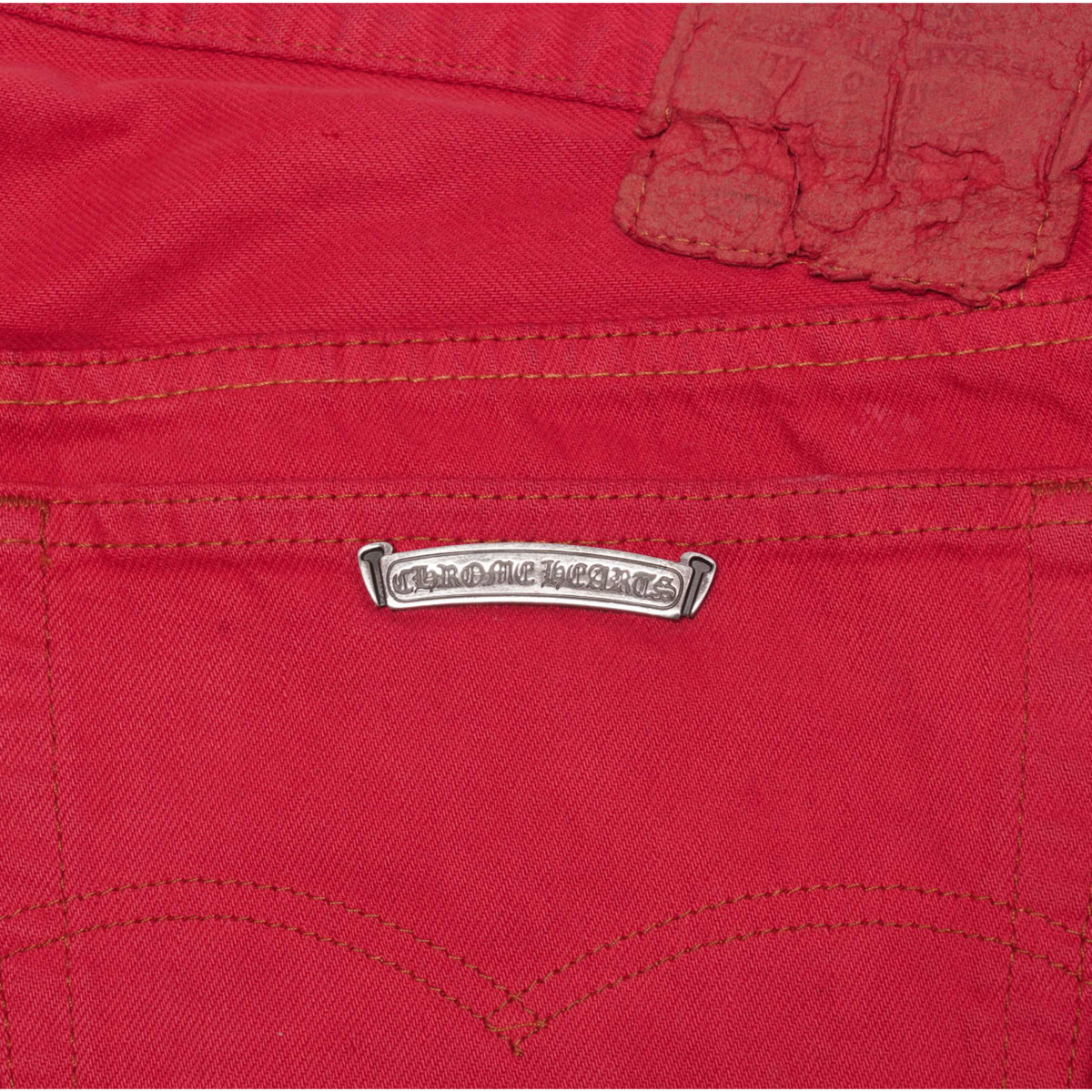 A detailed view focusing on the upper rear panel area, showcasing a classic spade-shaped rear patch utility pocket stitched cleanly with a matching red thread perimeter line below the tailored back yoke seam.