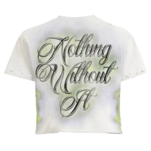 Back flat lay view of the cream Vertabrae 'Prayers' graphic tee, highlighting the seamless upper shoulder tailoring and relaxed streetwear drape, dominated by a large centralized screen-printed script graphic in elegant, multi-layered black and grey calligraphy reading 'Nothing Without It' overlaid onto matching airbrushed neon green and tan background halos.