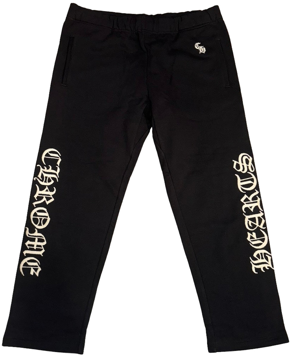 Front flat lay view of the Chrome Hearts 'Slo Ride' sweatpants in heavyweight jet-black cotton fleece, showcasing a relaxed-taper lounge silhouette, a comfortable gathered elastic waistband with tonal hidden drawstrings, and striking white embroidery reading 'CHROME' vertically down the right lower leg and 'HEARTS' down the left lower leg in signature heavy satin-stitched gothic lettering.