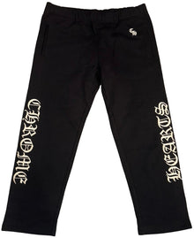 Front flat lay view of the Chrome Hearts 'Slo Ride' sweatpants in heavyweight jet-black cotton fleece, showcasing a relaxed-taper lounge silhouette, a comfortable gathered elastic waistband with tonal hidden drawstrings, and striking white embroidery reading 'CHROME' vertically down the right lower leg and 'HEARTS' down the left lower leg in signature heavy satin-stitched gothic lettering.