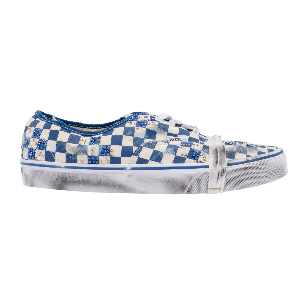 A lateral side profile view of the Vans x Mattias Gollin Authentic sneaker, showcasing a heavily washed, pre-distressed blue and cream canvas checkerboard upper with subtle frayed edges, custom handwritten ink doodles across the side fabric, white eyelets with white lacing, a clean white rubber foxing stripe, and a matching hand-vintaged vulcanized rubber midsole.